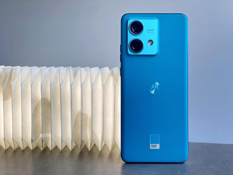 smartfon Motorola Edge 40 w kolorze niebieskim stojący na blacie tylną klapką do obiektywu
