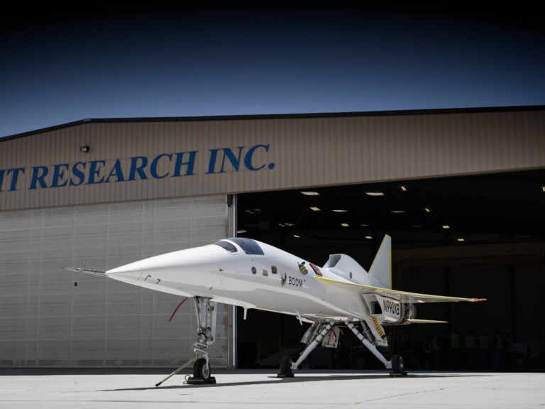 Biały odrzutowiec badawczy przed hangarem z napisem "Flight Research Inc."