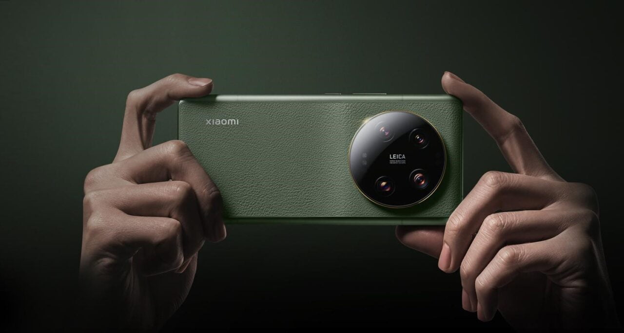 Smartphone Xiaomi 14 verde com câmera tripla Leica segurada com as duas mãos em um fundo verde escuro.