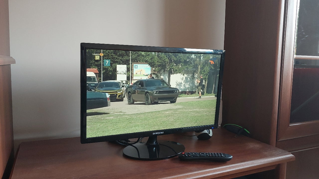Um monitor convertido em um carro de TV, apoiado em um gabinete.