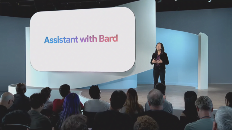 Prezentacja z kobietą mówiącą na scenie, w tle duży ekran z napisem "Assistant with Google Bard Advanced", przed nią widownia słuchająca prezentacji.