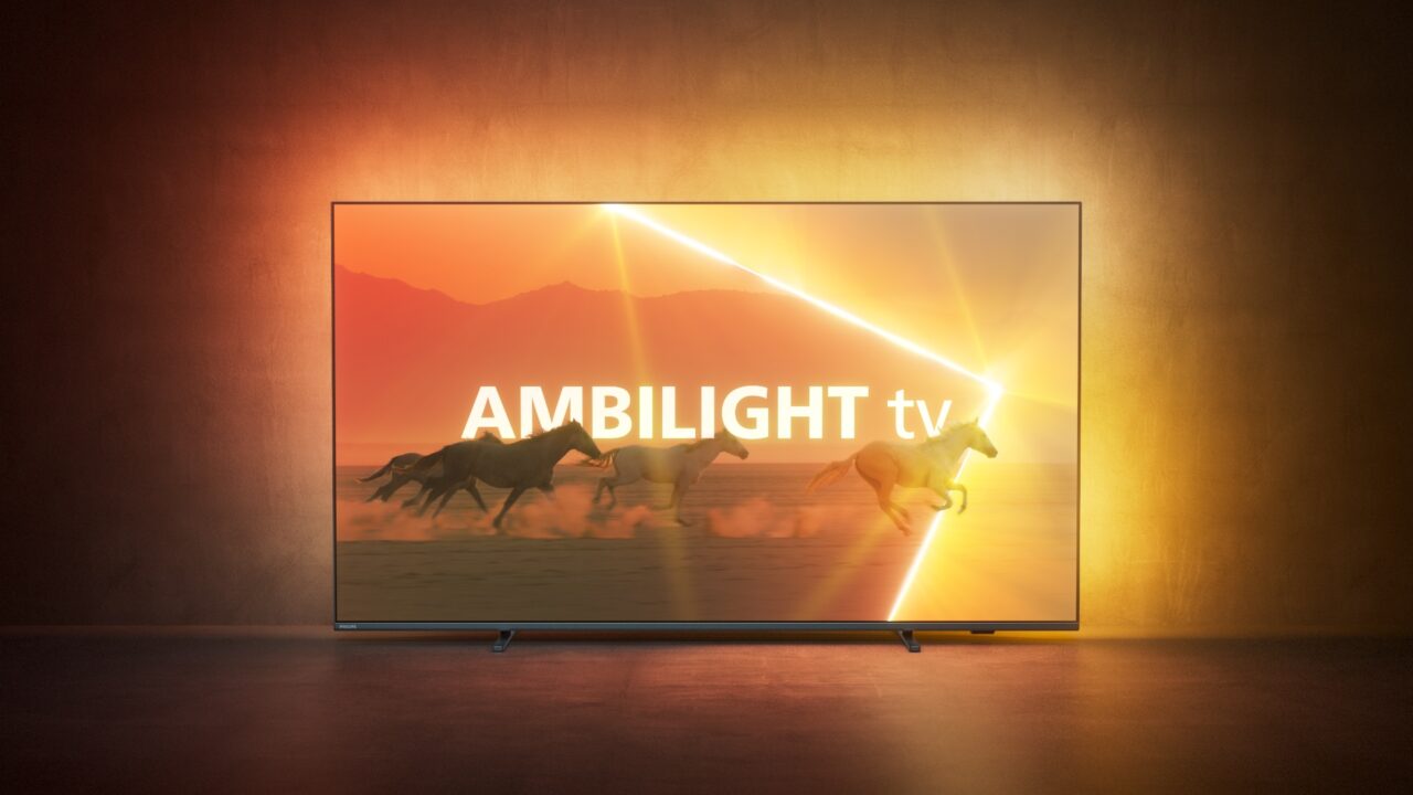Telewizor Philips Ambilight 9008 umieszczony w pokoju, a w tle ciepłe odcienie kolorystyczne