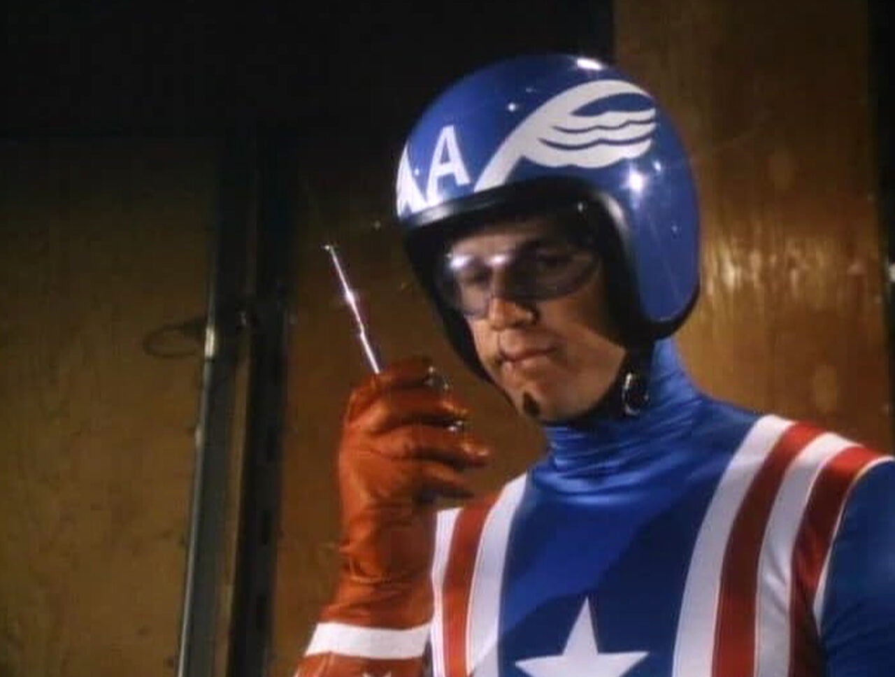 Reb Brown jako Kapitan Ameryka w filmie z 1979 roku. Aktor w charakterystycznym niebiesko czerwonym kostiumie trzymający walkie talkie