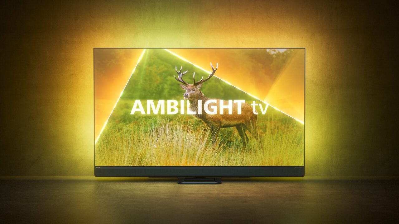 Telewizor Philips Ambilight 9308 widoczny od frontu z podświetleniem rozświetlającym tło w kolorach żółto-zielonych