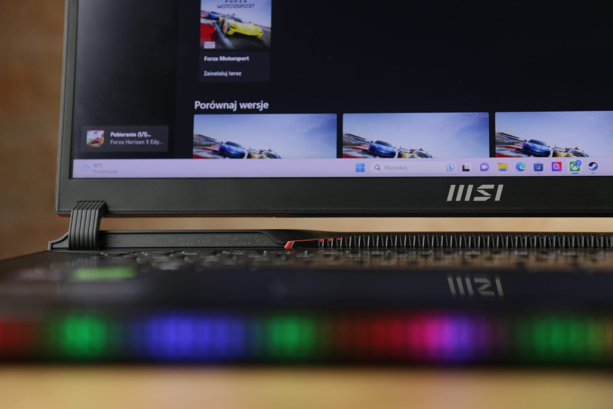 Logo recenzowanego laptopa MSI Raider GE78 HX 13V na pokrywie z widocznym oświetleniem RGB