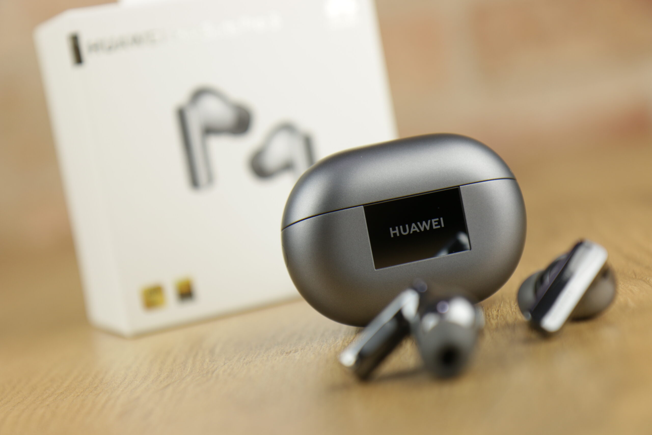 Recenzowane słuchawki Huawei FreeBuds Pro 3. Na pierwszym planie pchełki, drugim etui, trzecim pudełko