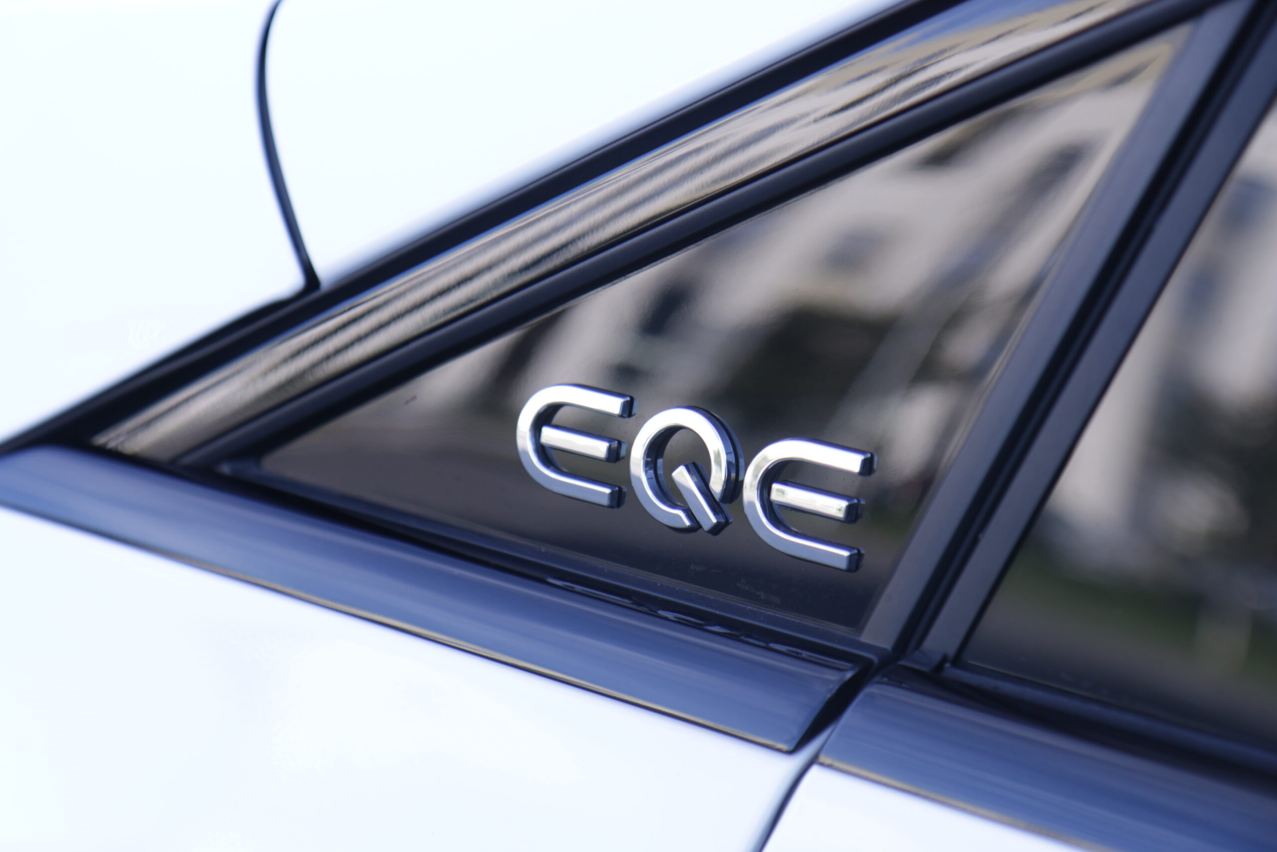Logo EQE testowanego Mercedesa EQE SUV 350 4MATIC na słupku A