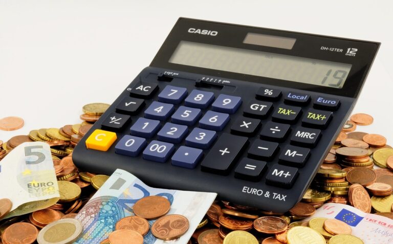 kalkulator casio w kolorze czarnym leżący na monetach i banknotach