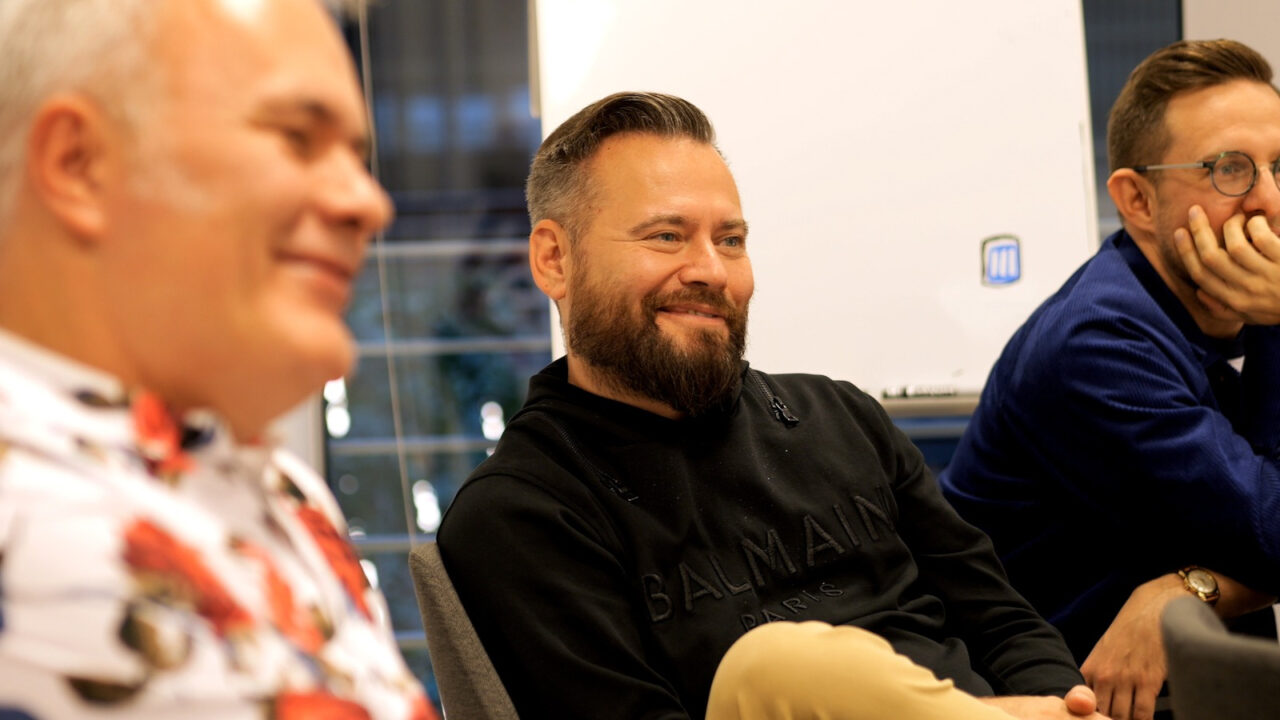 Trzej uśmiechnięci mężczyźni siedzący w pomieszczeniu biurowym. Od lewej: Mazurek, Stanowski i Gapiński. Drugi z nich założył Kanał Zero.