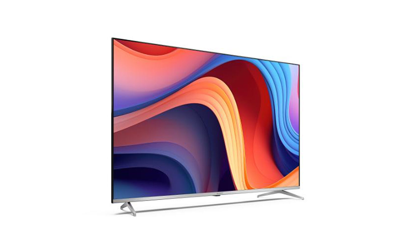 Nowoczesny telewizor z płaskim ekranem wyświetlający kolorowy, abstrakcyjny obraz, na białym tle, z dwoma prostymi nóżkami jako podstawą.