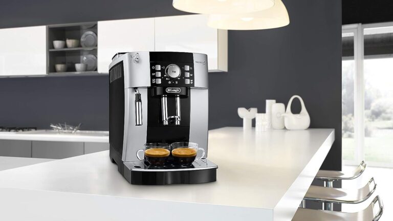 Ekspres do kawy marki De'Longhi umieszczony na białym blacie kuchennym, z dwoma filiżankami espresso.