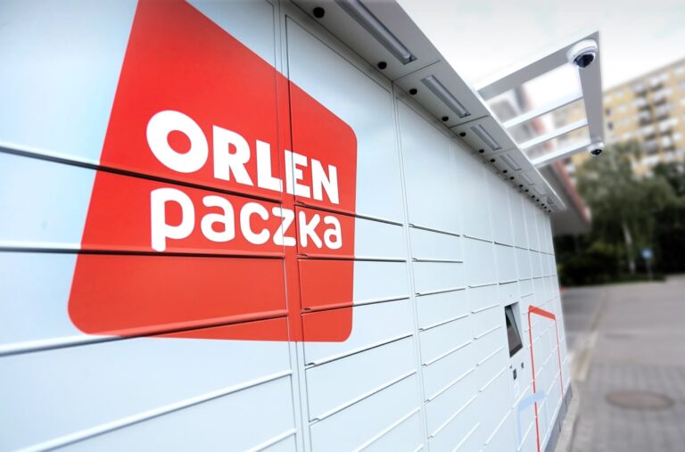 Automat paczkowy Orlen Paczka sfotografowany od boku z dużym czerwonym logo firmy.