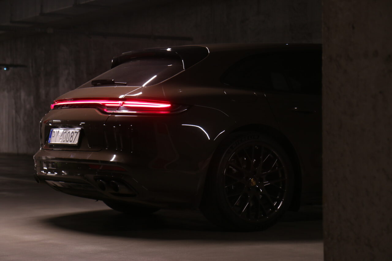 Tył testowanego Porsche Panamera 4S E-Hybrid Sport Turismo w ciemnym garażu z włączonymi światłami
