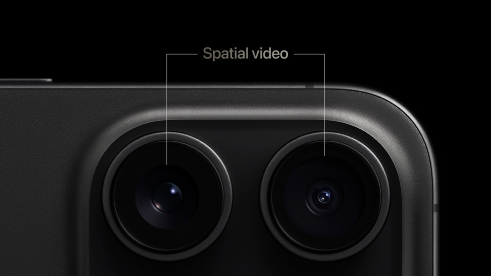 Podwójny aparat fotograficzny smartfona iPhone z podpisem "Spatial video" nad górną krawędzią.