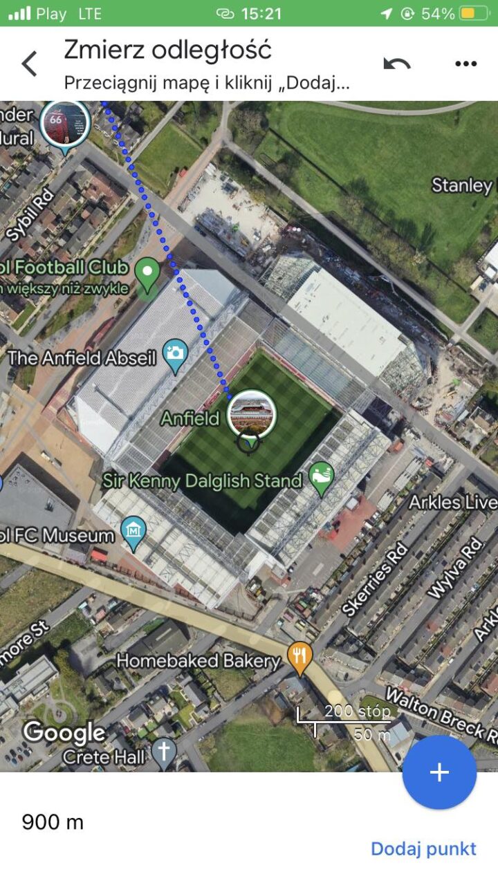 Satelitarny widok stadionu Anfield wraz z oznaczonymi punktami zainteresowania takimi jak The Anfield Abseil i Sir Kenny Dalglish Stand oraz trasą pomiaru odległości przebiegającą obok stadionu.