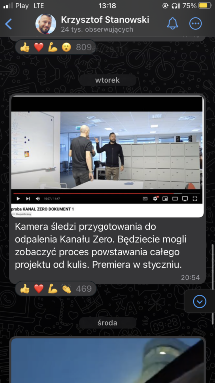 Zrzut ekranu z interfejsu użytkownika aplikacji społecznościowej prezentujący post użytkownika o nazwie Krzysztof Stanowski z fragmentem wideo, na którym dwaj mężczyźni rozmawiają w biurowym wnętrzu; jeden z nich wskazuje coś na tablicy.