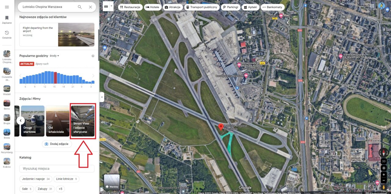 Zrzut ekranu z widokiem satelitarnym Lotniska Chopina w Warszawie na mapie Google, z aktywnym oknem wyszukiwania oraz widocznymi opcjami nawigacyjnymi, takimi jak restauracje i hotele, a także wybranym zdjęciem Street View lotniska.