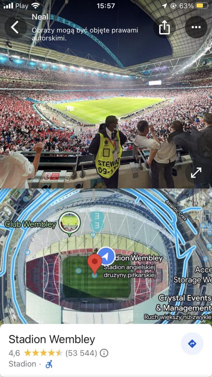 Widok wnętrza wypełnionego kibicami Stadionu Wembley podczas meczu, w dolnej części obrazu widoczny screenshot z aplikacji mapowej z zaznaczonym stadionem.