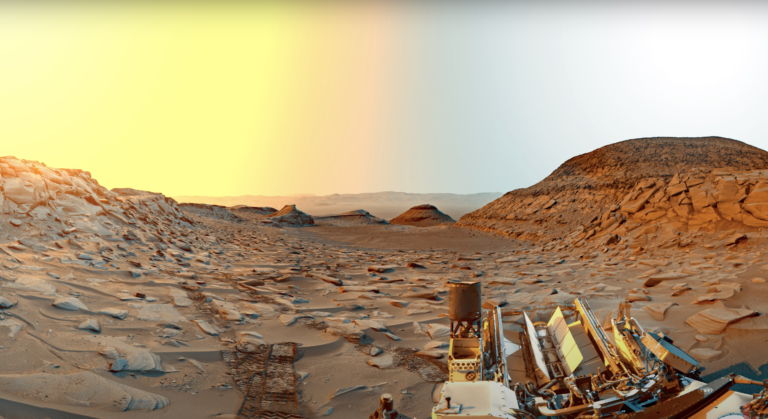 Panorama powierzchni Marsa z widocznym łazikiem marsjańskim.