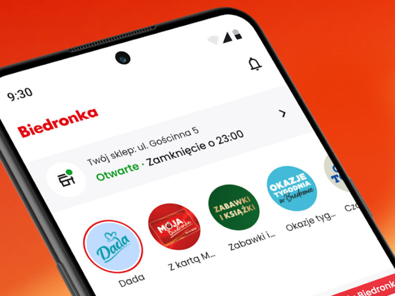 Widok ekranu smartfona z otwartą aplikacją sklepu Biedronka, pokazującą informacje o godzinach otwarcia i promocjach.