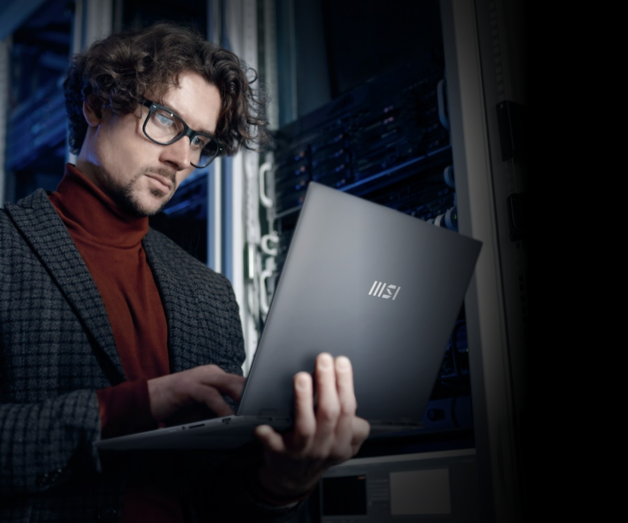 Mężczyzna z okularami używa laptopa marki MSI