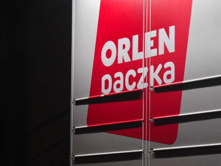 Szaro-czerwona paczkomatowa skrytka z logo "ORLEN paczka".