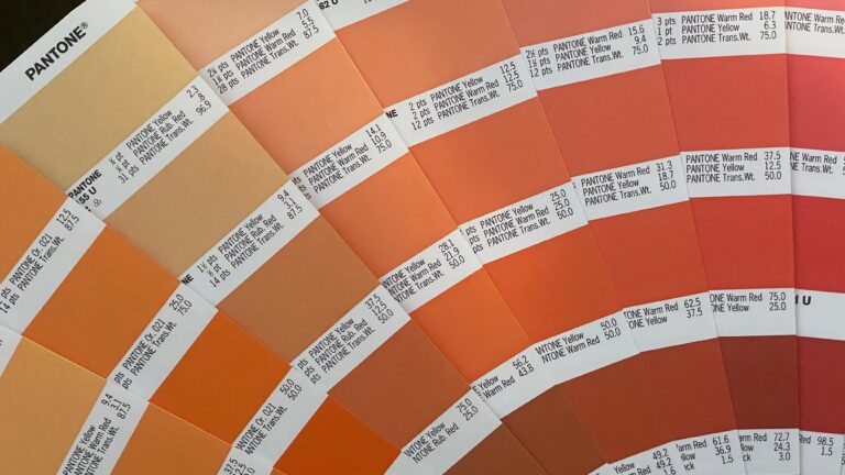 Paleta kolorów Pantone z próbkami odcieni pomarańczowych i czerwonych, każda z oznaczeniem i proporcjami mieszania barw.