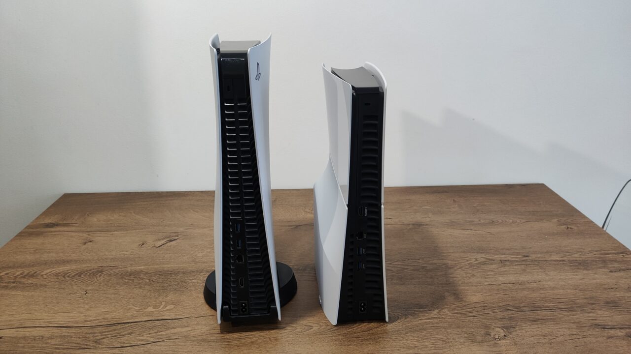PlayStation 5 oraz PlayStation 5 Slim w kolorze czarnym i białym stoją obok siebie na drewnianym biurku.