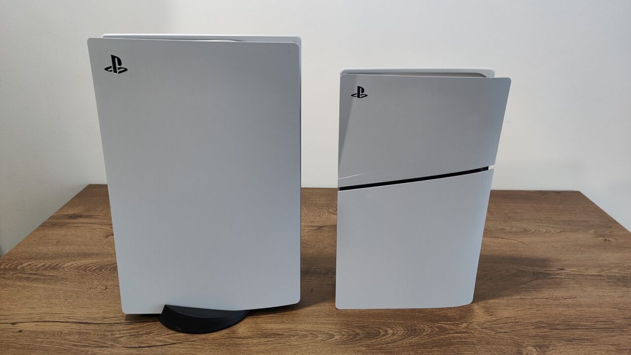 PlayStation 5 oraz PlayStation 5 Slim w kolorze czarnym i białym stoją obok siebie na drewnianym biurku.