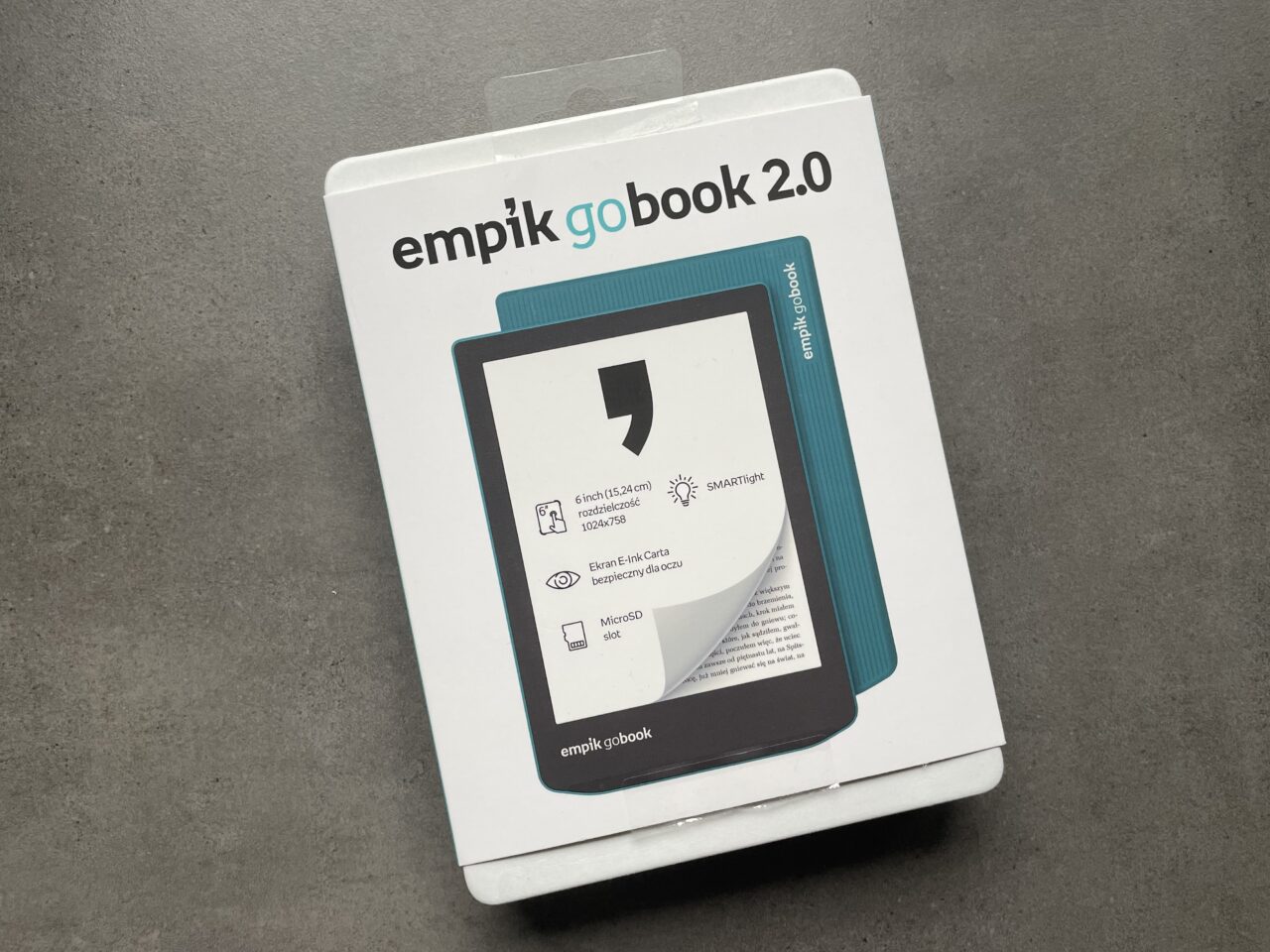 Opakowanie czytnika e-booków Empik GoBook 2.0 leżące na szarym tle.