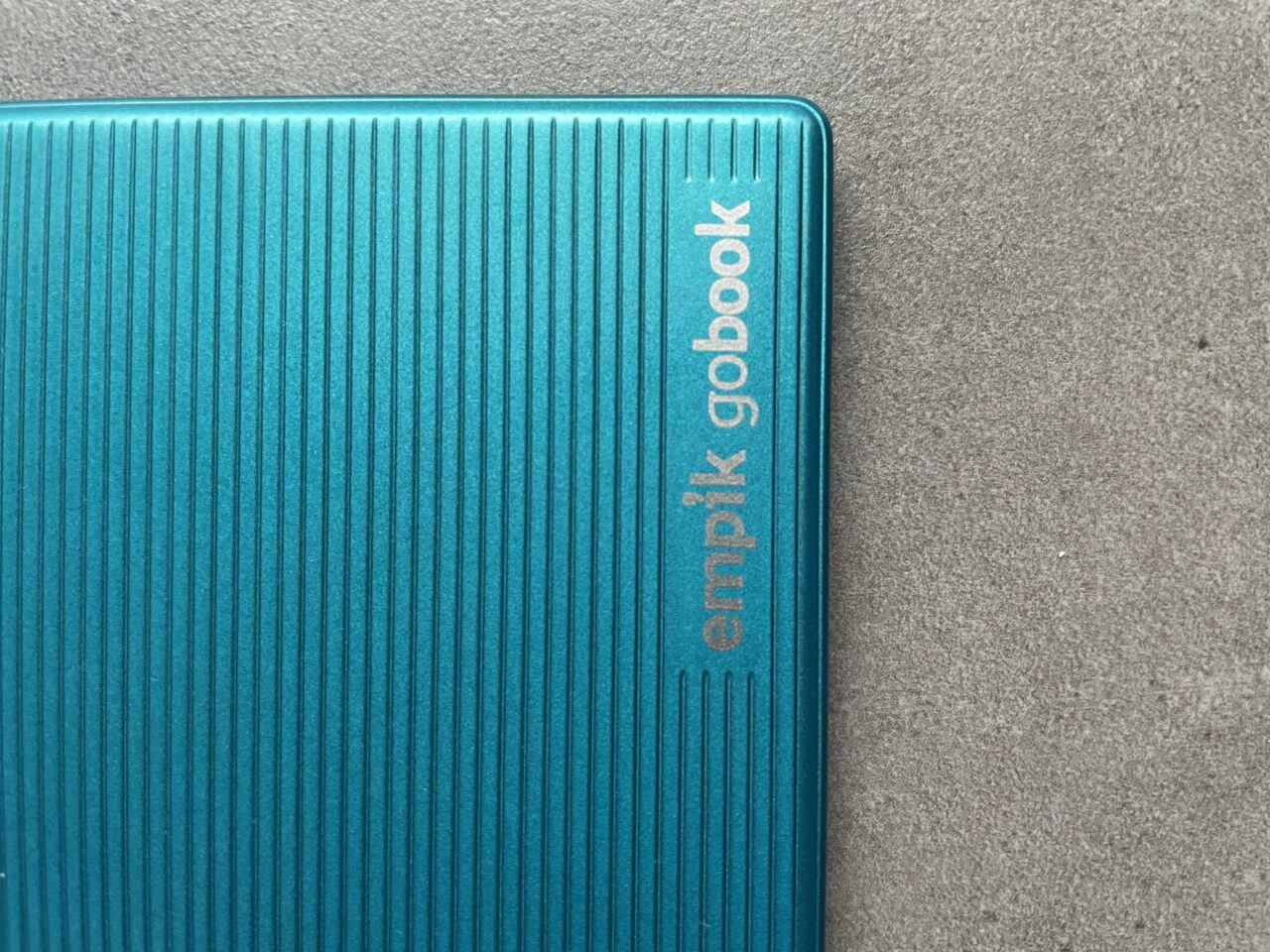 Niebieska okładka czytnika ebooków z wytłoczonym napisem "empik gobook" na szarym tle.