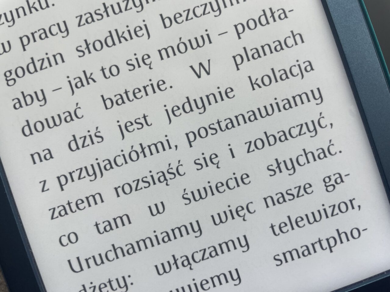 Zbliżenie na ekran czytnika e-booków wyświetlający tekst w języku polskim.