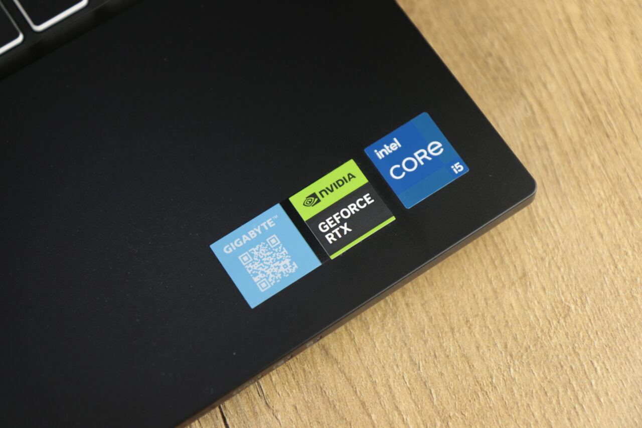 Naklejki logo firm GIGABYTE, NVIDIA GeForce RTX i Intel CORE i5 na czarnej powierzchni laptopa Gigabyte G5 MF (2023).