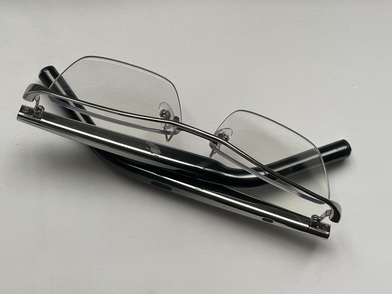Okulary bezramkowe z przezroczystymi szkłami położone na białym tle.