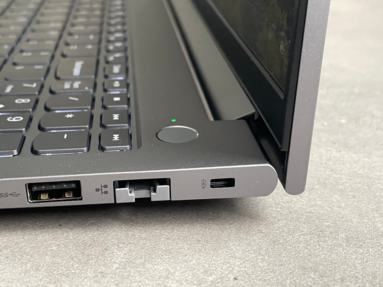 Część boczna laptopa z widocznymi portami USB, HDMI, złączem do dokowania i wskaźnikiem zasilania.