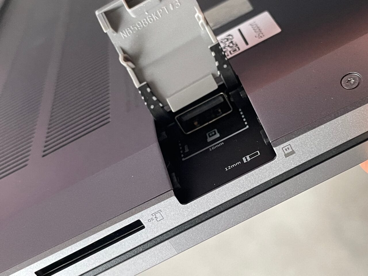 Adapter do karty SD włożony do laptopa z wyraźnie oznaczonymi wyjściami dla kart o różnych rozmiarach.