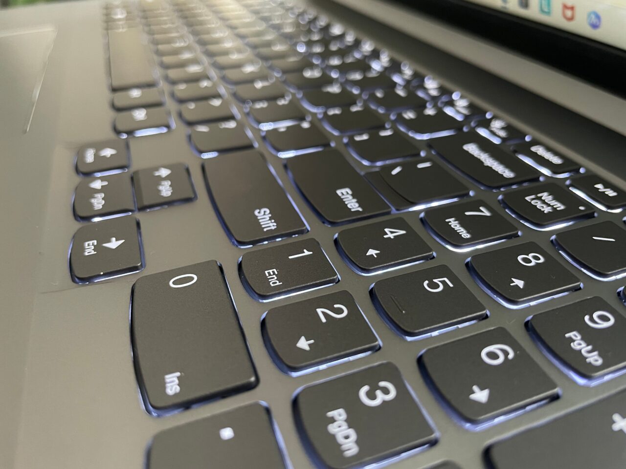 Klawiatura komputera z podświetlanymi klawiszami, perspektywa skośna części bloku numerycznego i klawiszy funkcyjnych.