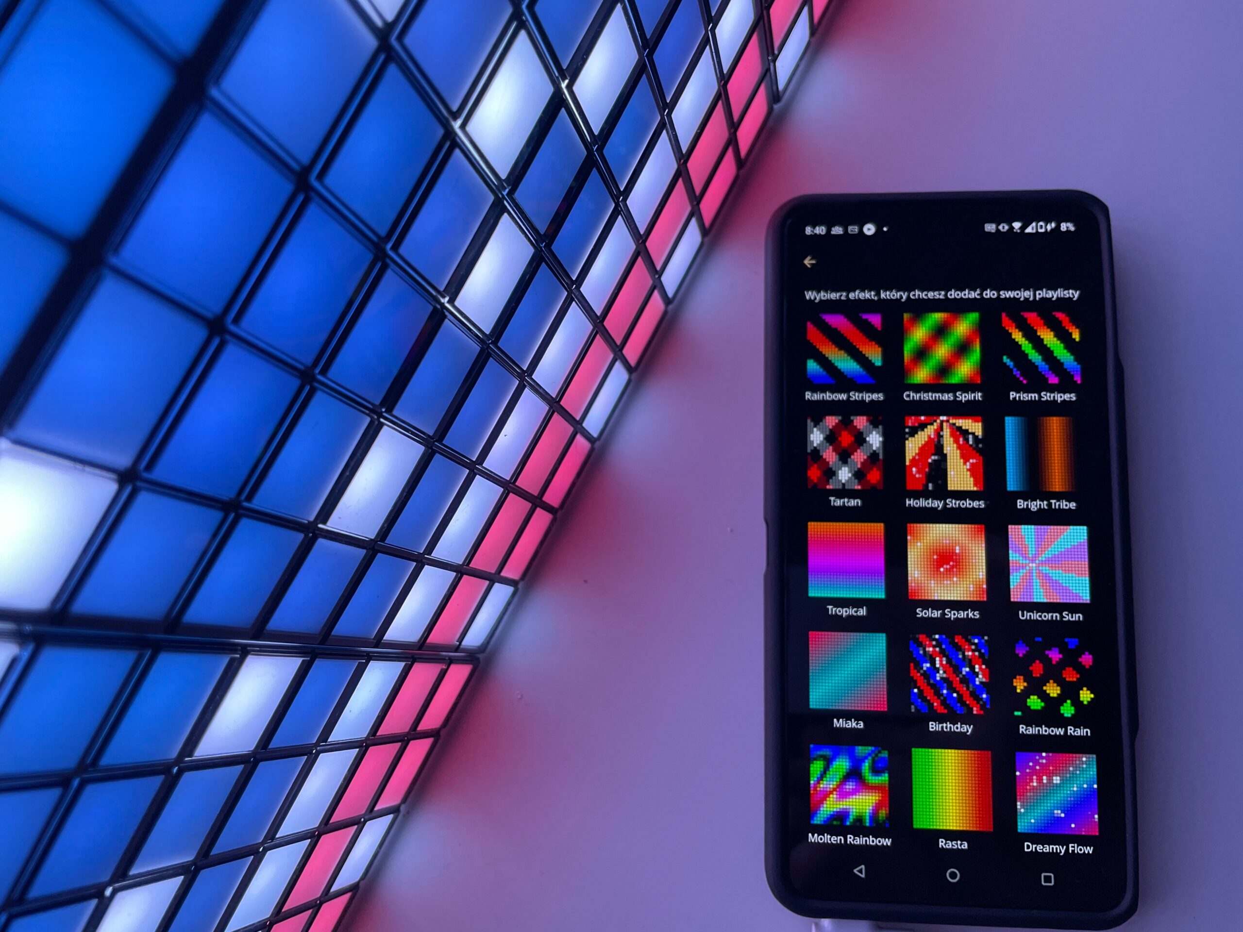 Smartfon leżący na podświetlanej, kolorowej siatce LED wyświetla aplikację z różnymi efektami świetlnymi do wyboru.