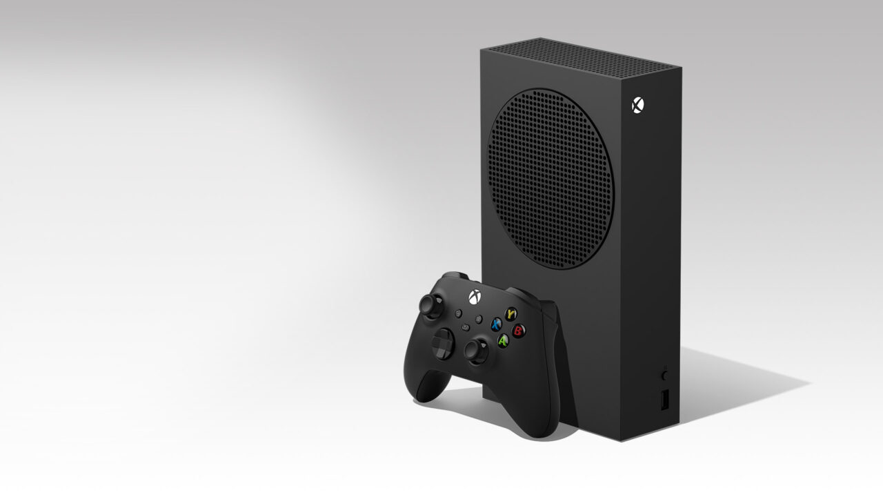 Konsola do gier Microsoft Xbox Series S z czarnym kontrolerem na jasnoszarym tle.