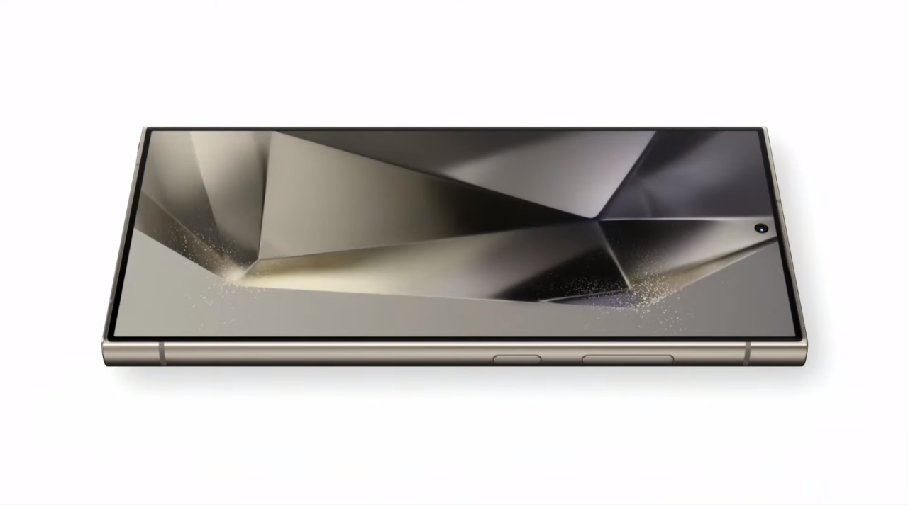 Smartfon Galaxy S24 Ultra leżący ekranem do góry z grafiką przypominającą abstrakcyjne, błyszczące płaszczyzny na białym tle.