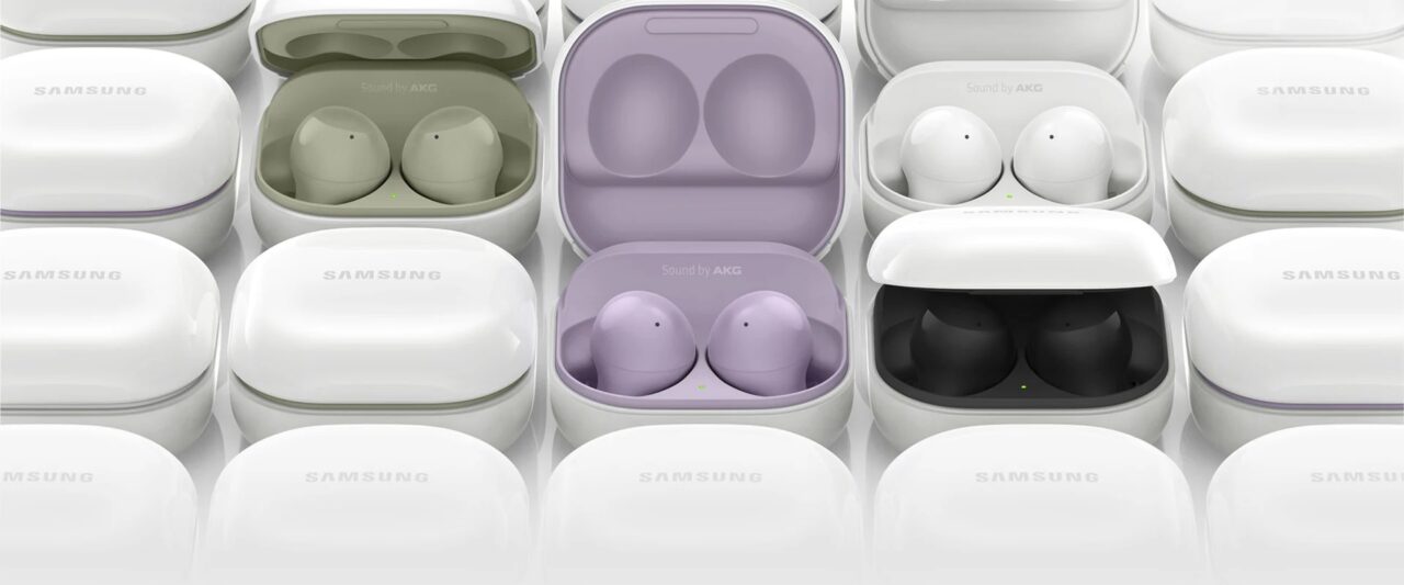 Zdjęcie różnych kolorowych słuchawek Samsung Galaxy Buds w otwartych etui, ułożonych w równoległe rzędy.