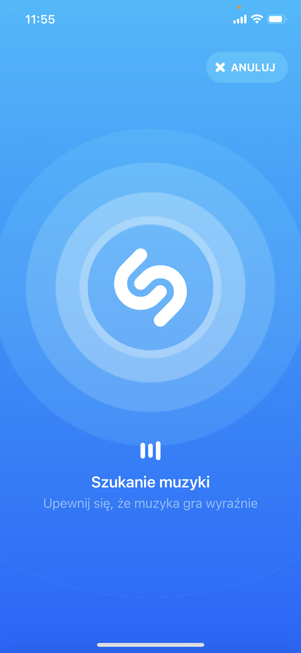 Ekran aplikacji do rozpoznawania muzyki Shazam z centralnym symbolem w kształcie spirali, napisem "Szukanie muzyki" oraz ikonami stanu baterii i siły sygnału w prawym górnym rogu, a także przyciskiem "ANULUJ" na górze pośrodku.