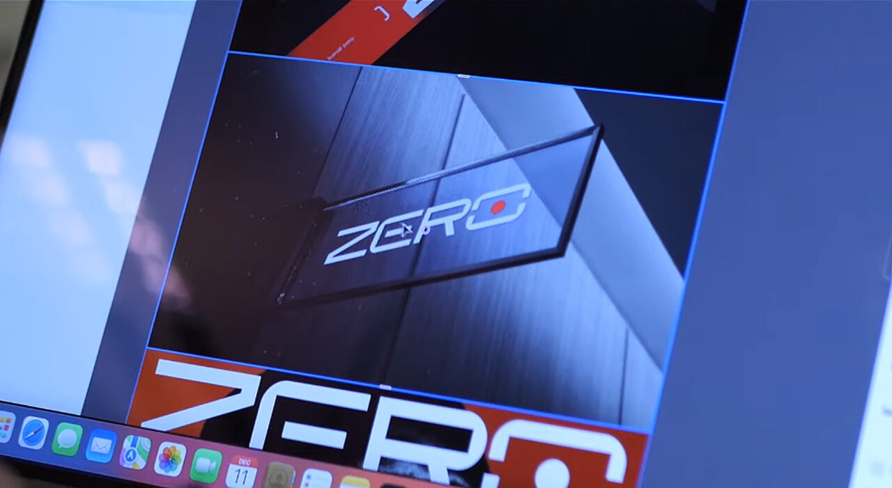 Ekran komputera z widocznym graficznym logo Kanał Zero w stylizowanej prezentacji, z elementami czerwonego i czarnego koloru oraz odbiciami świetlnymi.