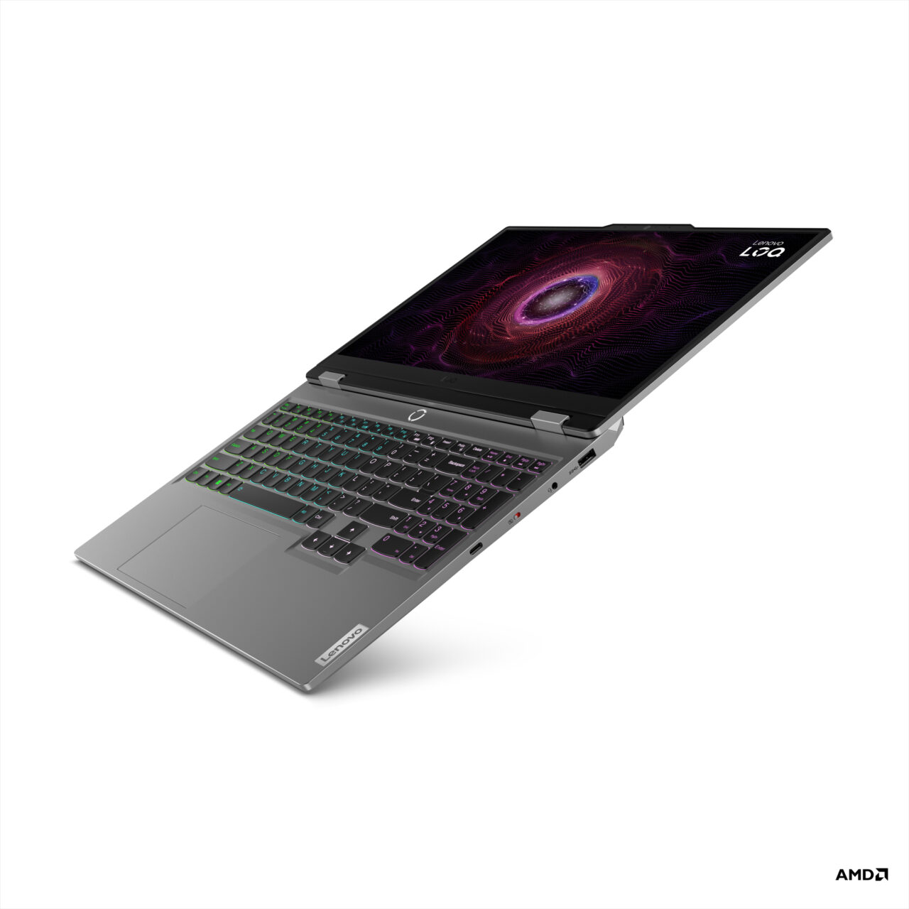 Laptop gamingowy umieszczony po przekątnej z podświetlaną klawiaturą RGB i grafiką z okiem na ekranie, logo AMD w narożniku.
