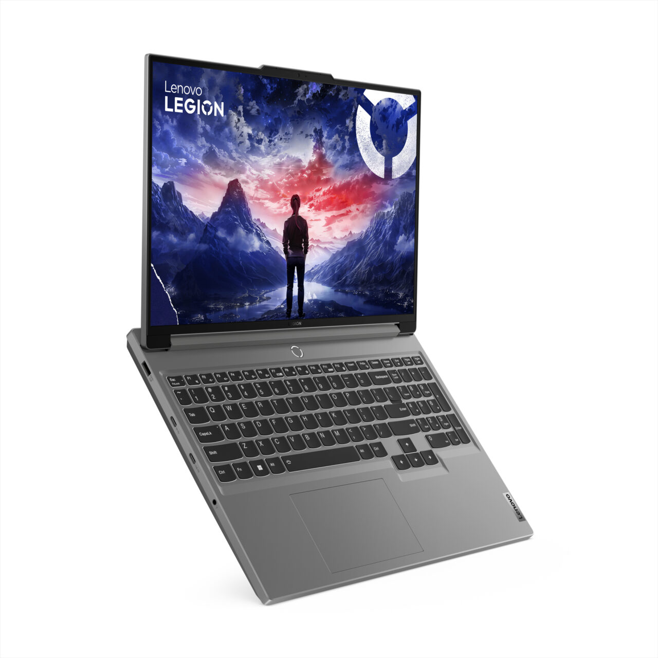 Laptop Lenovo Legion z otwartym ekranem przedstawiającym ilustrację osoby stojącej na tle górskiego krajobrazu o zachodzie słońca.