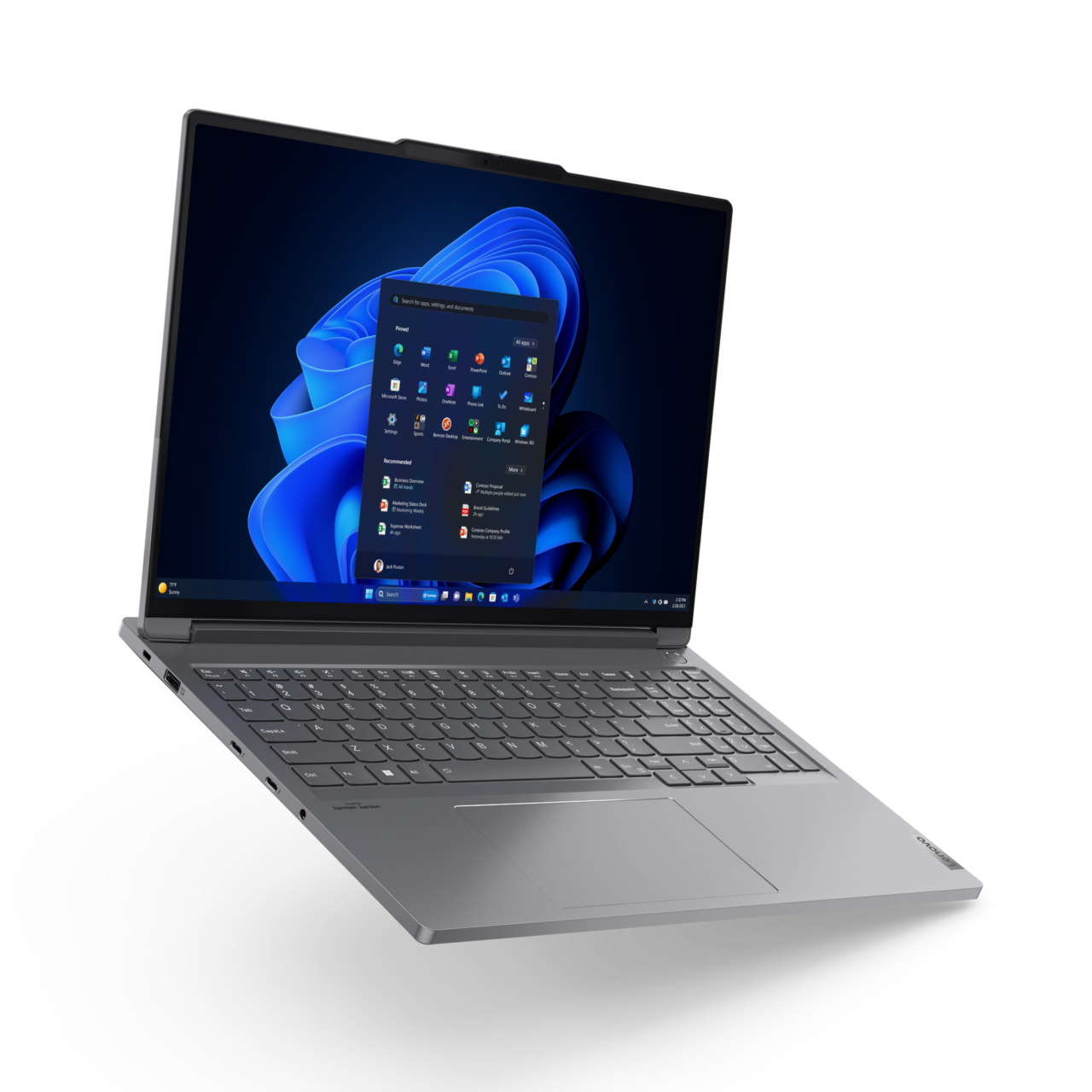Otwarty, srebrny laptop z zalogowanym ekranem startowym systemu Windows na jednolitym tle.