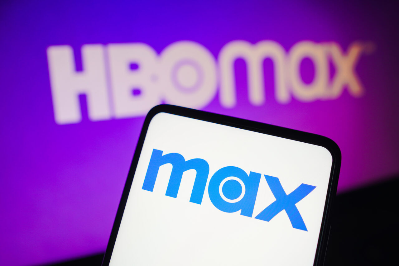 Nowości w HBO Max. Smartfon z logo Max na pierwszym planie i rozmytym logo HBO Max w tle. Wiemy kiedy Max w Polsce zagości