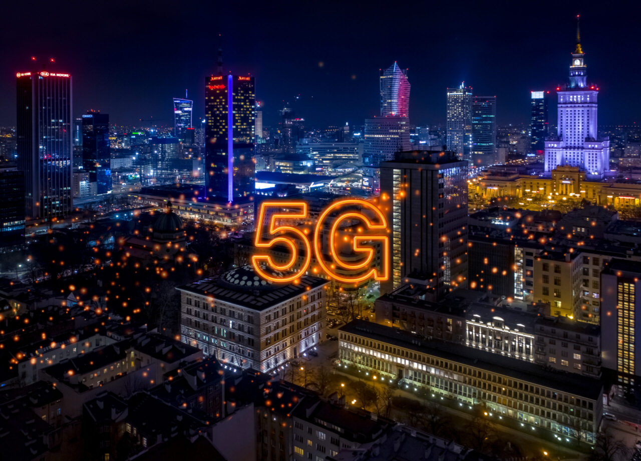 Warszawa nocą, pomarańczowe punkty, pomarańczowy napis 5G na środku