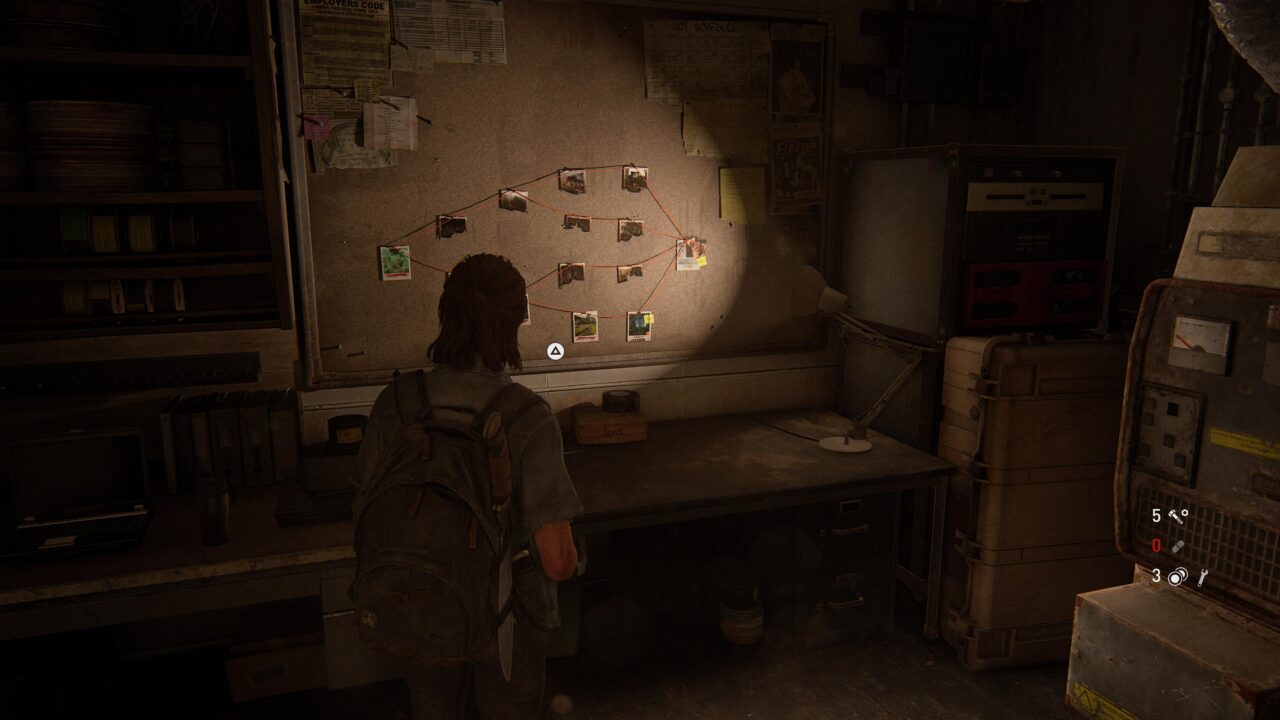 Postać w grze komputerowej ogląda tablicę ogłoszeń z różnymi notatkami i zdjęciami połączonymi liniami, w zaniedbanym, ciemnym pomieszczeniu z biurkiem i sprzętem elektronicznym.