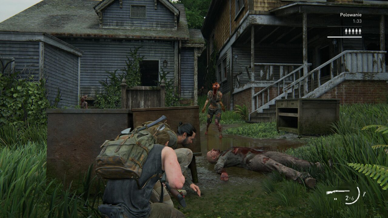 Scena z gry wideo przedstawiająca postać skradającą się z zagiętym nożem za plecami w kierunku przeciwnika wyglądającego jak zombie na tle zaniedbanego drewnianego domu. Obok leży ciało innego przeciwnika w kałuży wody. Na ekranie widoczne elementy interfejsu użytkownika, w tym licznik amunicji i ikony postaci.